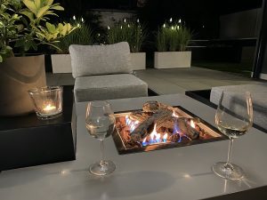Feuertisch am Abend mit Weingläsern