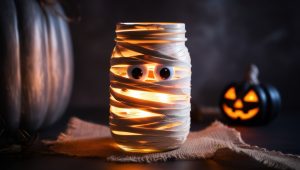 Halloween Tischdeko: Einmachglas umwickelt mit Mullbinden, mit Augen und Licht im Inneren, Mumien-Optik