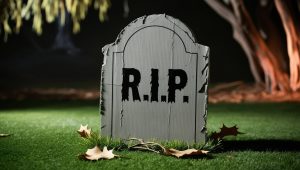 Halloween Grabstein aus Pappe mit R.I.P. Aufschrift, auf einem Rasen, gruselige Stimmung